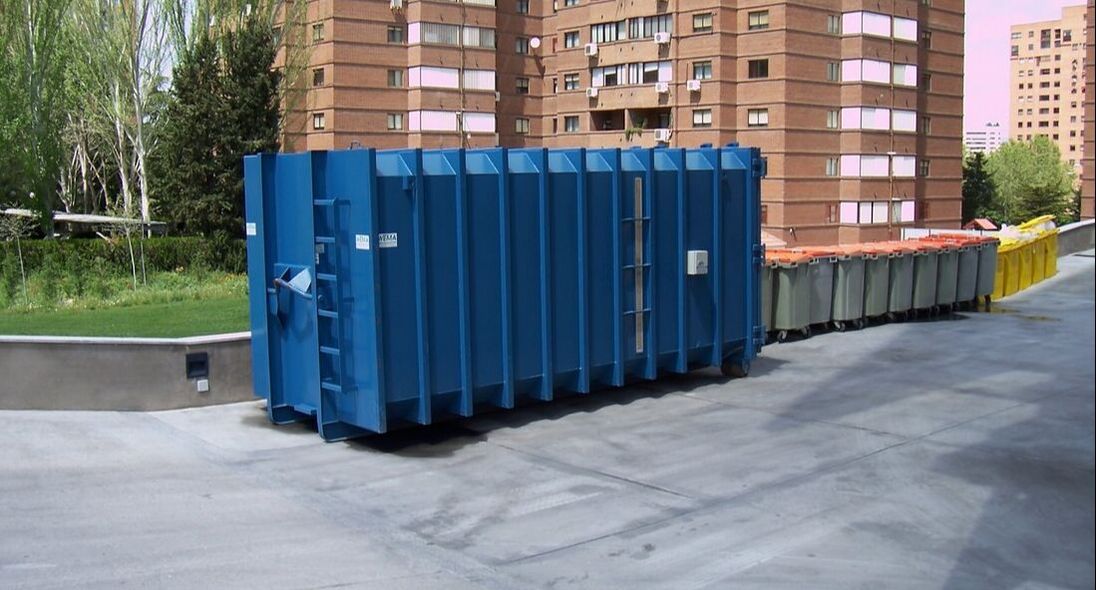 blue 40 yard container placed strategically outside a large apartment complex